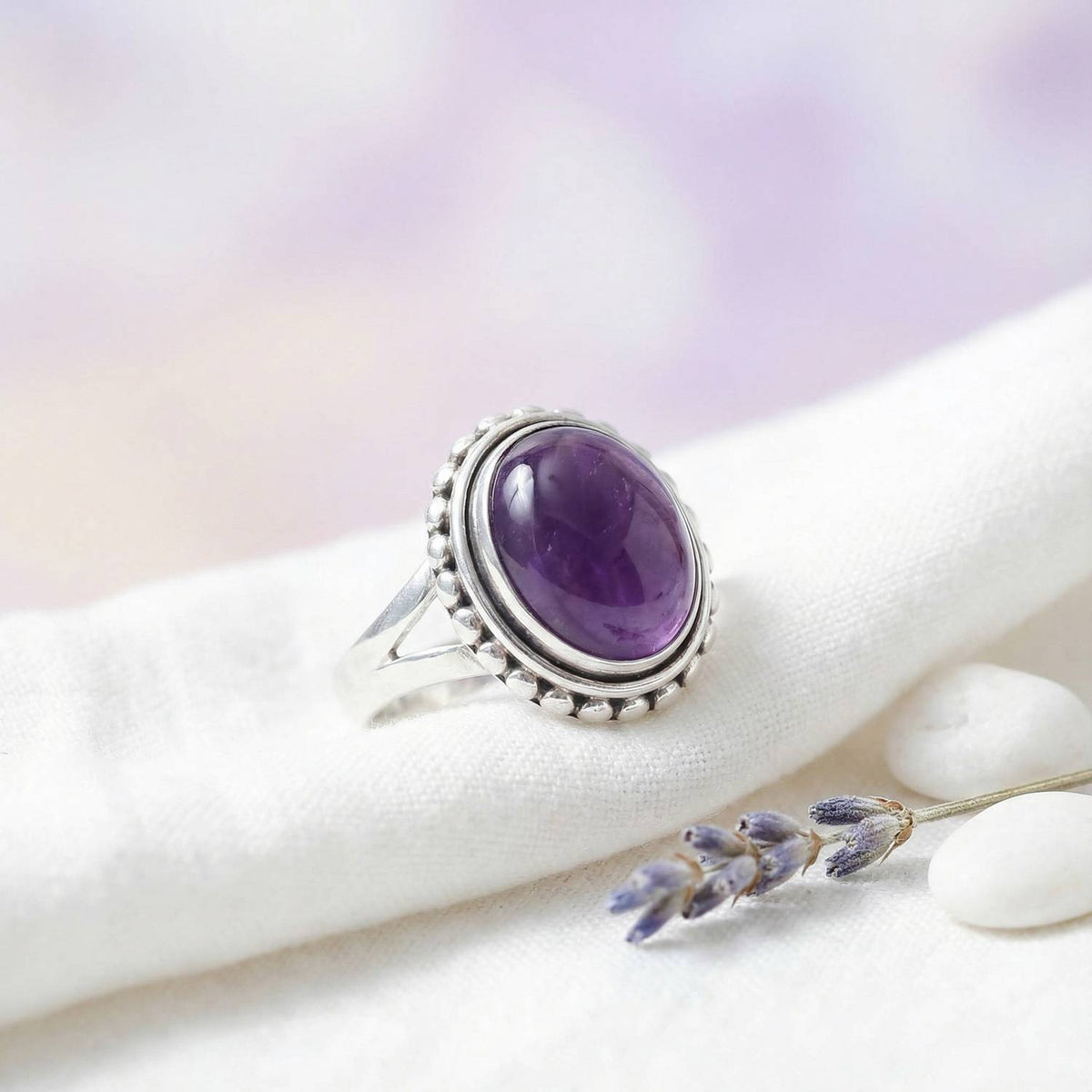Silberring mit Amethyst auf hellem Stoff