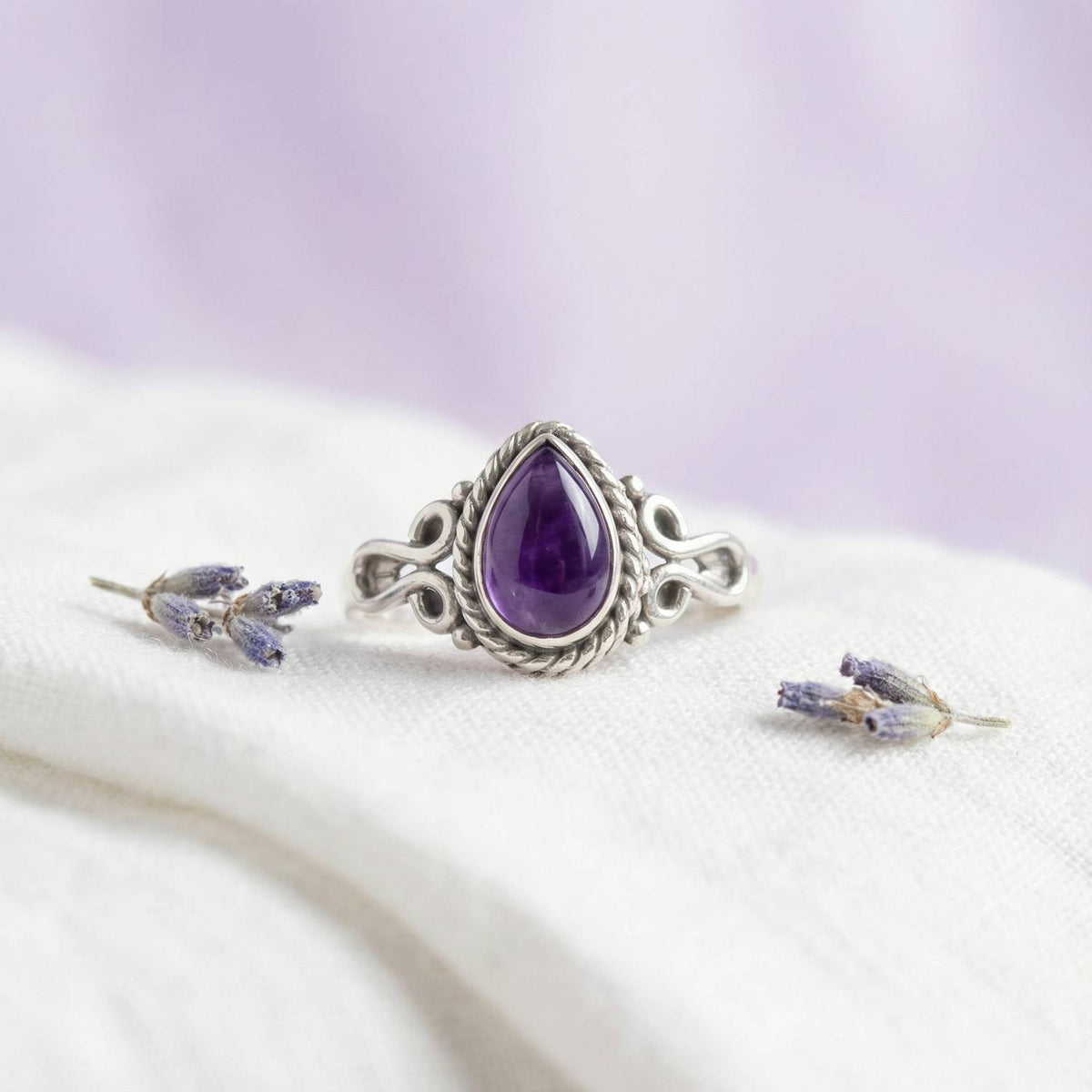 Silberring mit Amethyst auf hellem Stoff