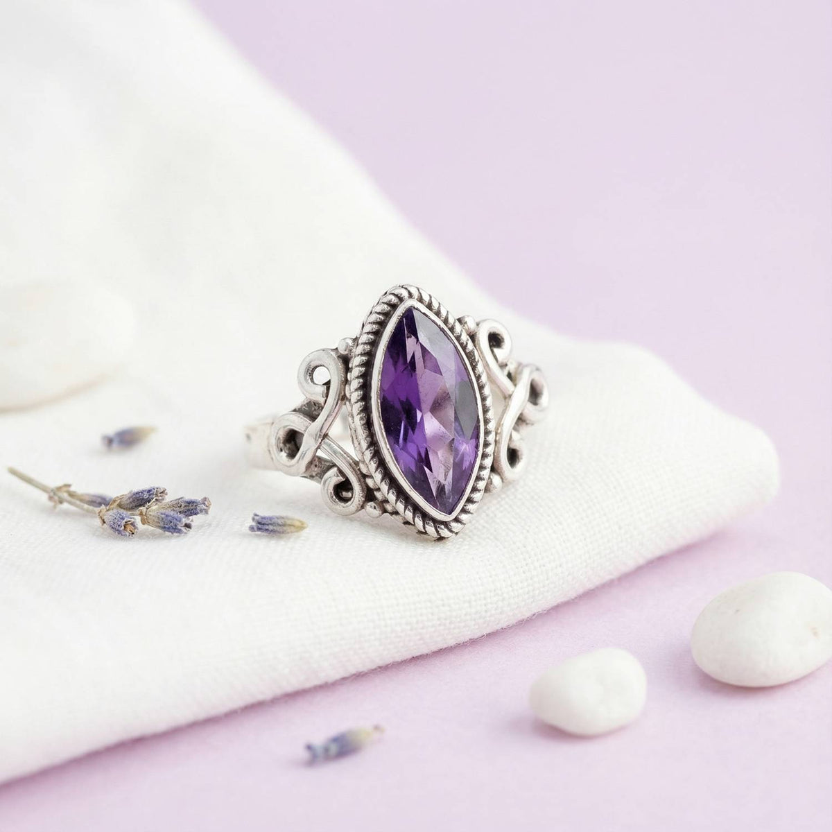 Silberring mit Amethyst auf hellem Stoff