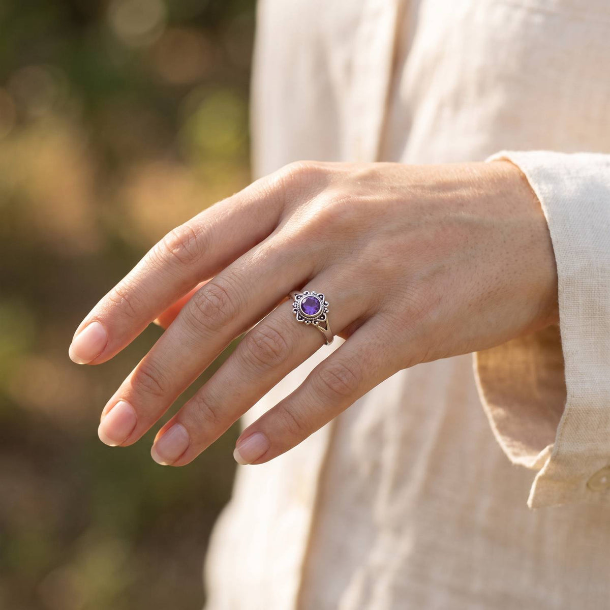 Amethystring aus Silber getragen an der Hand im Freien