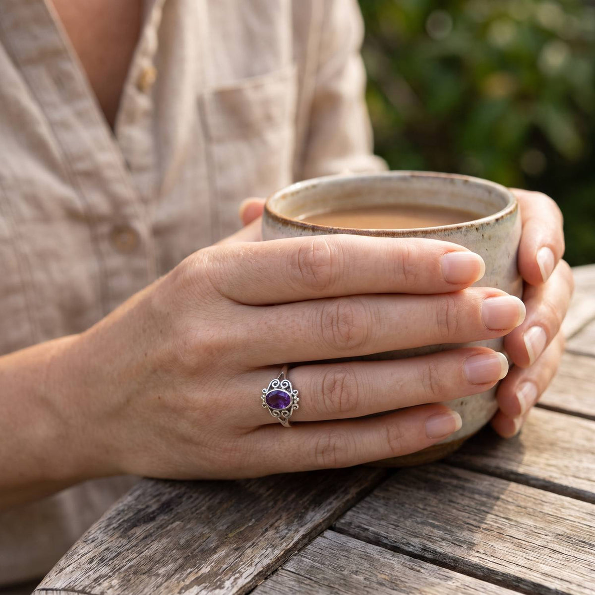 Amethystring aus Silber getragen beim Lesen mit einer Tasse