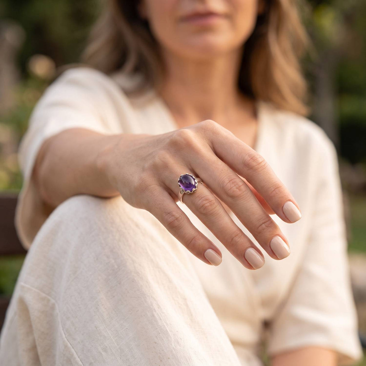 Amethystring aus Silber getragen an der Hand im Freien