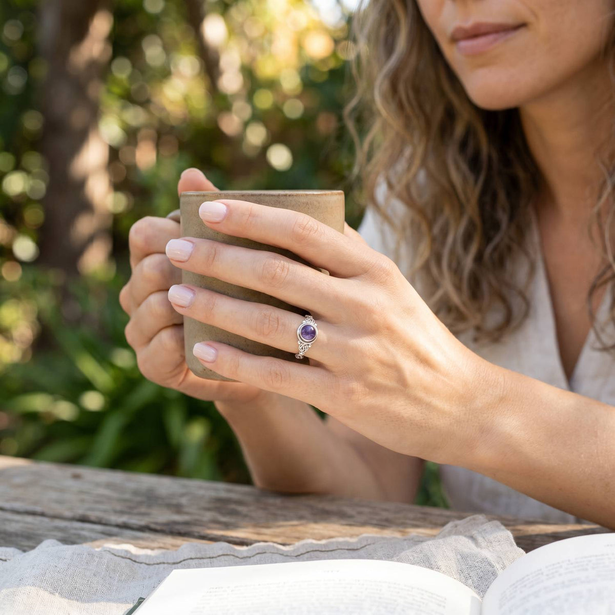 Amethystring aus Silber getragen beim Lesen mit einer Tasse