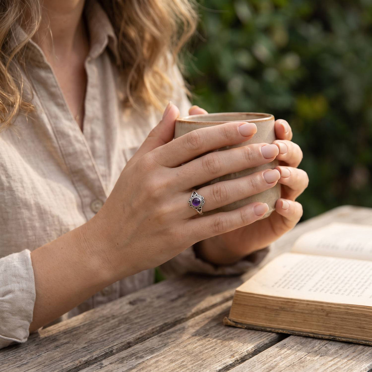 Amethystring aus Silber getragen beim Lesen mit einer Tasse