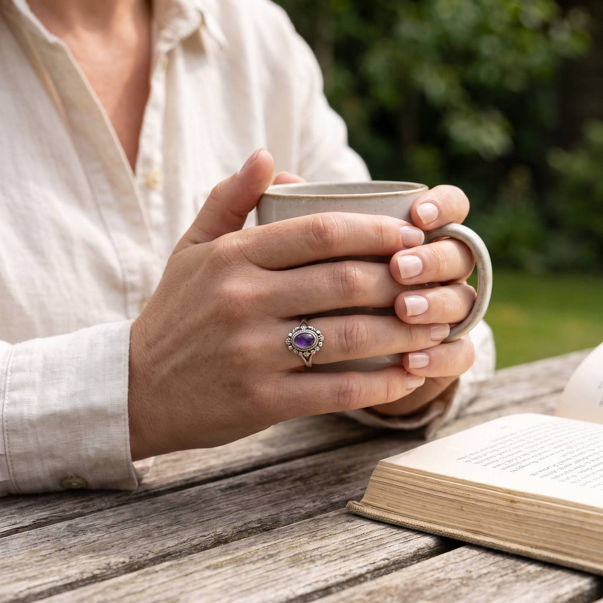 Amethystring aus Silber getragen beim Lesen mit einer Tasse