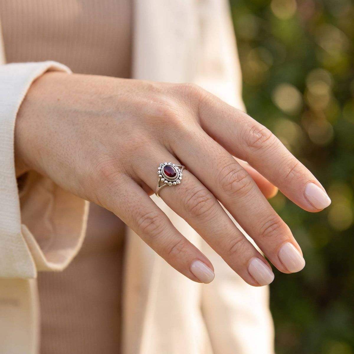 Granatring aus Silber getragen an der Hand im Freien