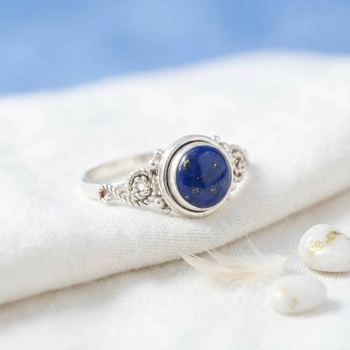 Silberring mit Lapislazuli auf hellem Stoff