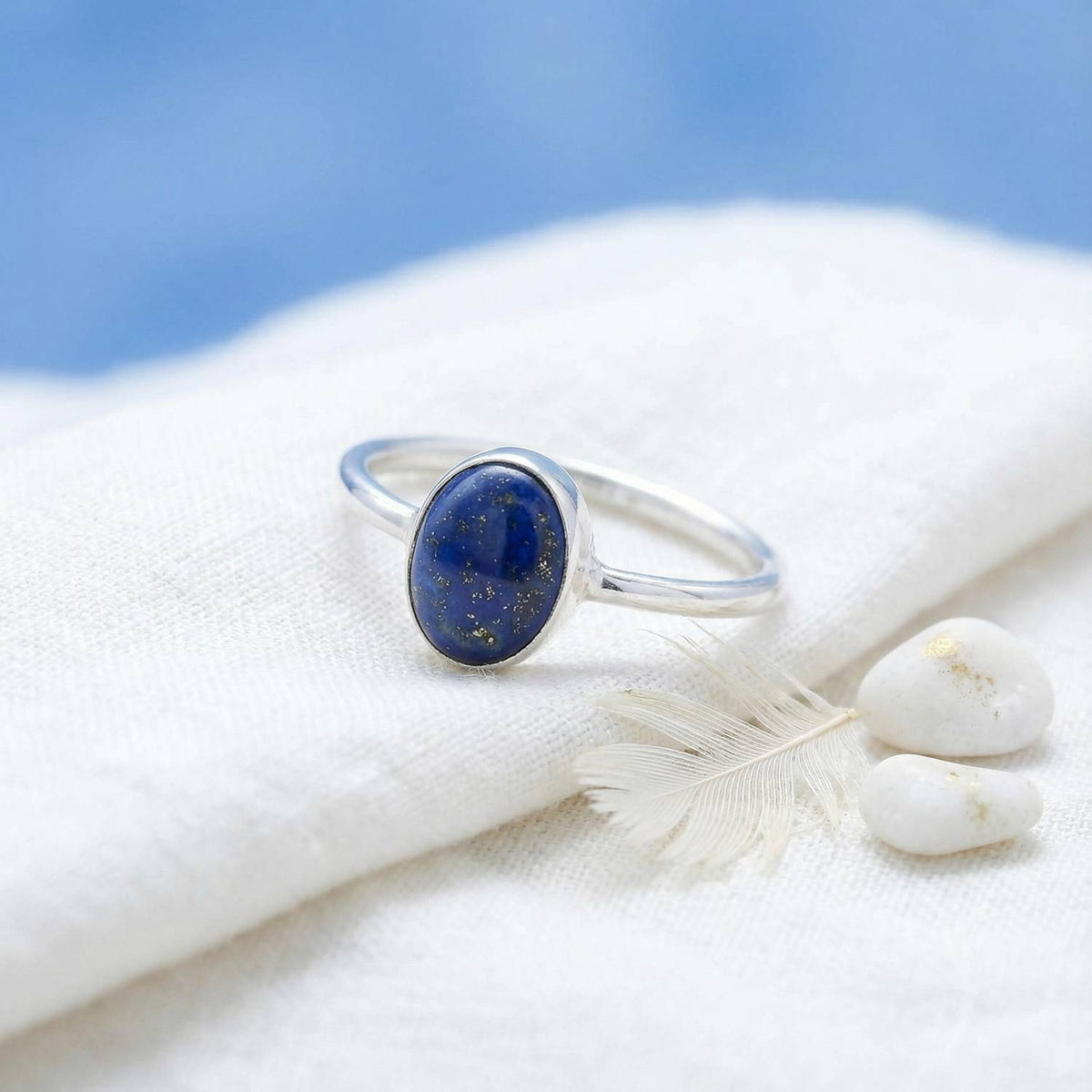 Silberring mit Lapislazuli auf hellem Stoff