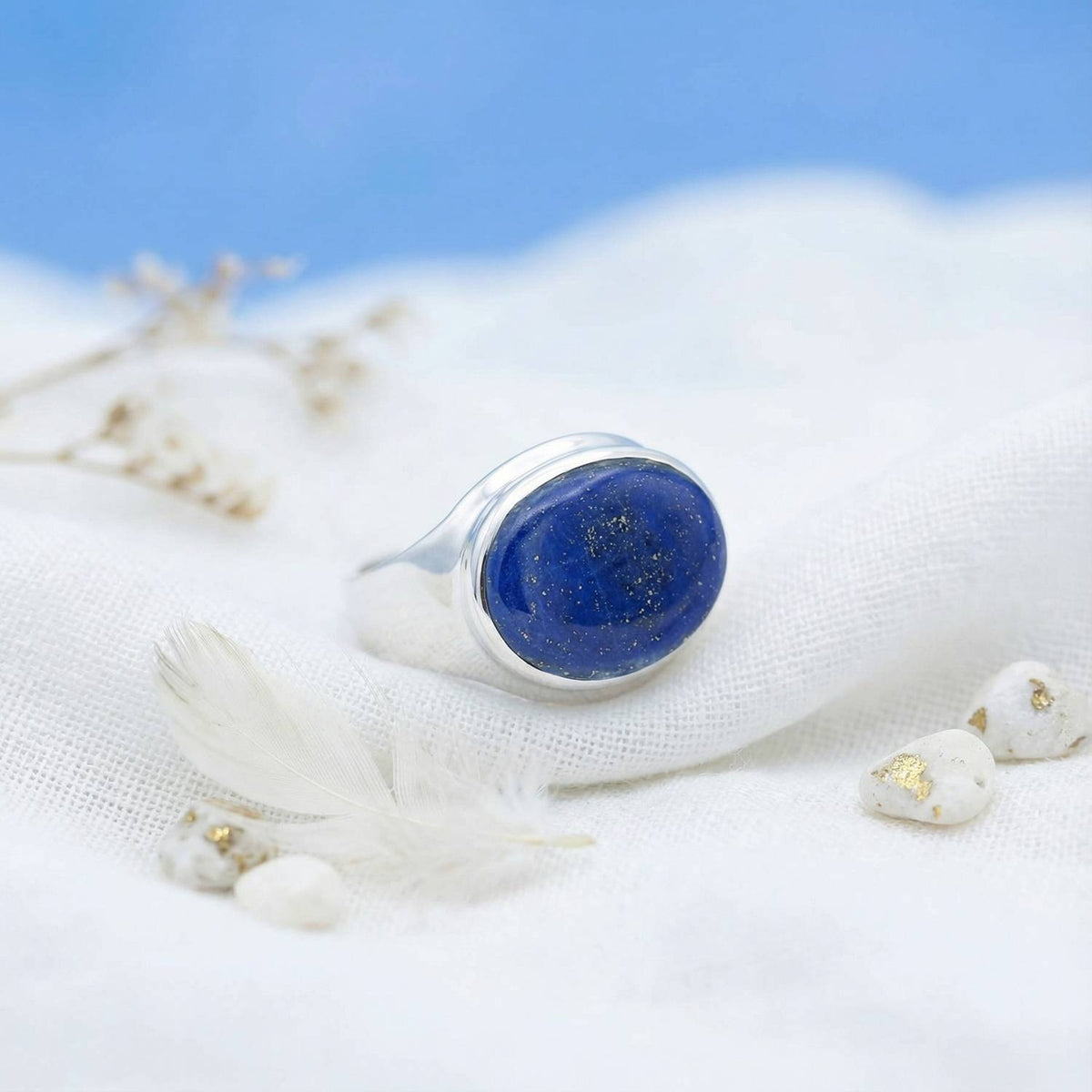 Silberring mit Lapislazuli auf hellem Stoff