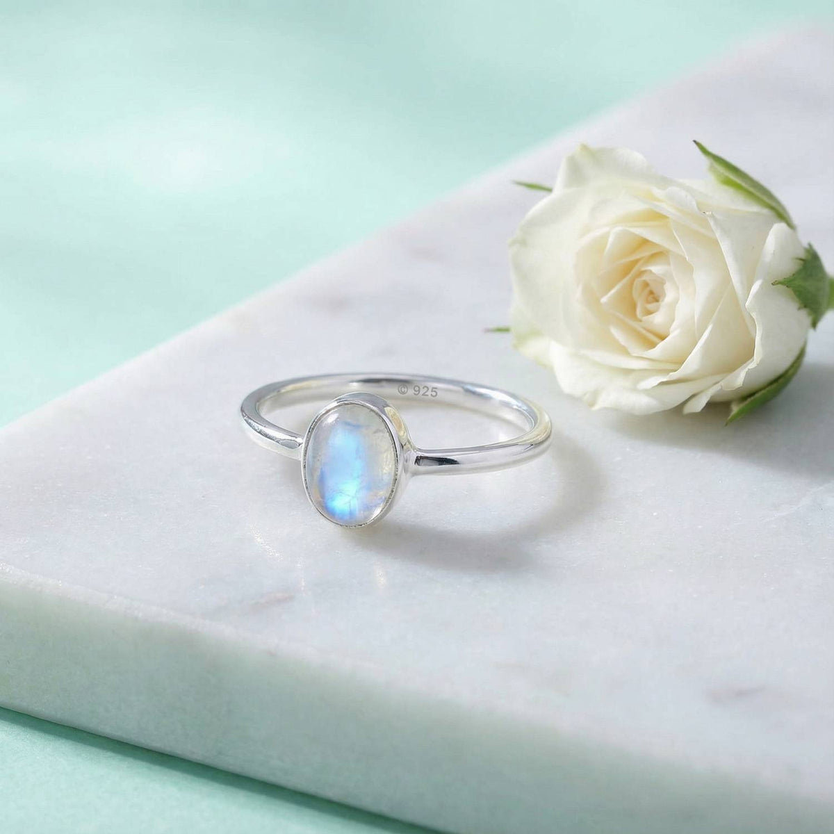 Silberring mit Mondstein auf hellem Stoff