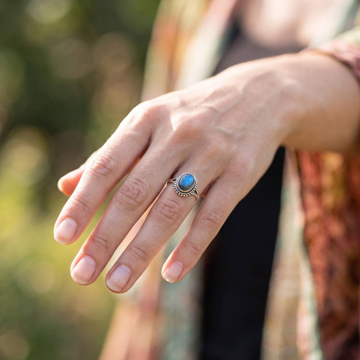 Labradoritring aus Silber getragen an der Hand im Freien