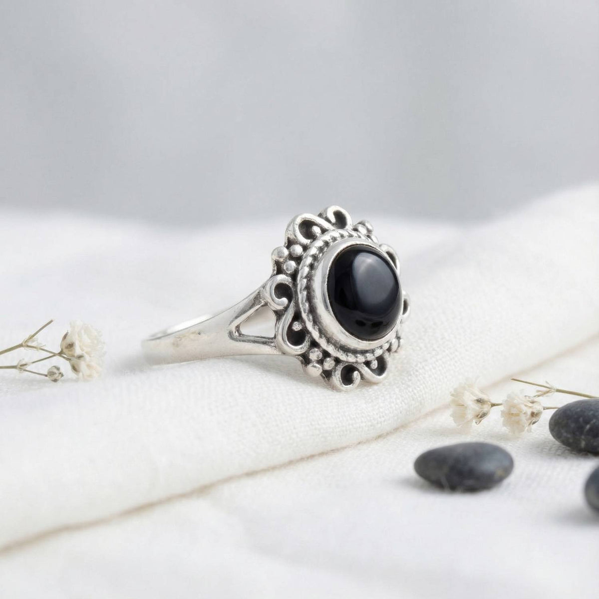Silberring mit Onyx auf hellem Stoff