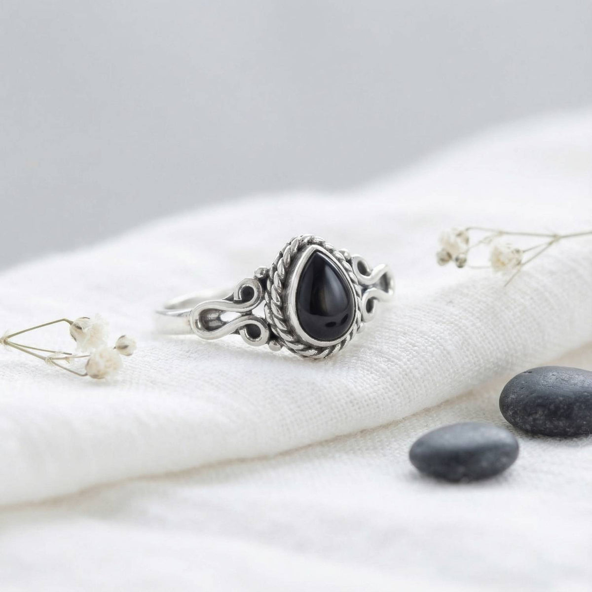 Silberring mit Onyx auf hellem Stoff
