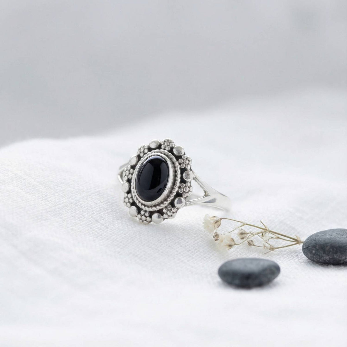 Silberring mit Onyx auf hellem Stoff
