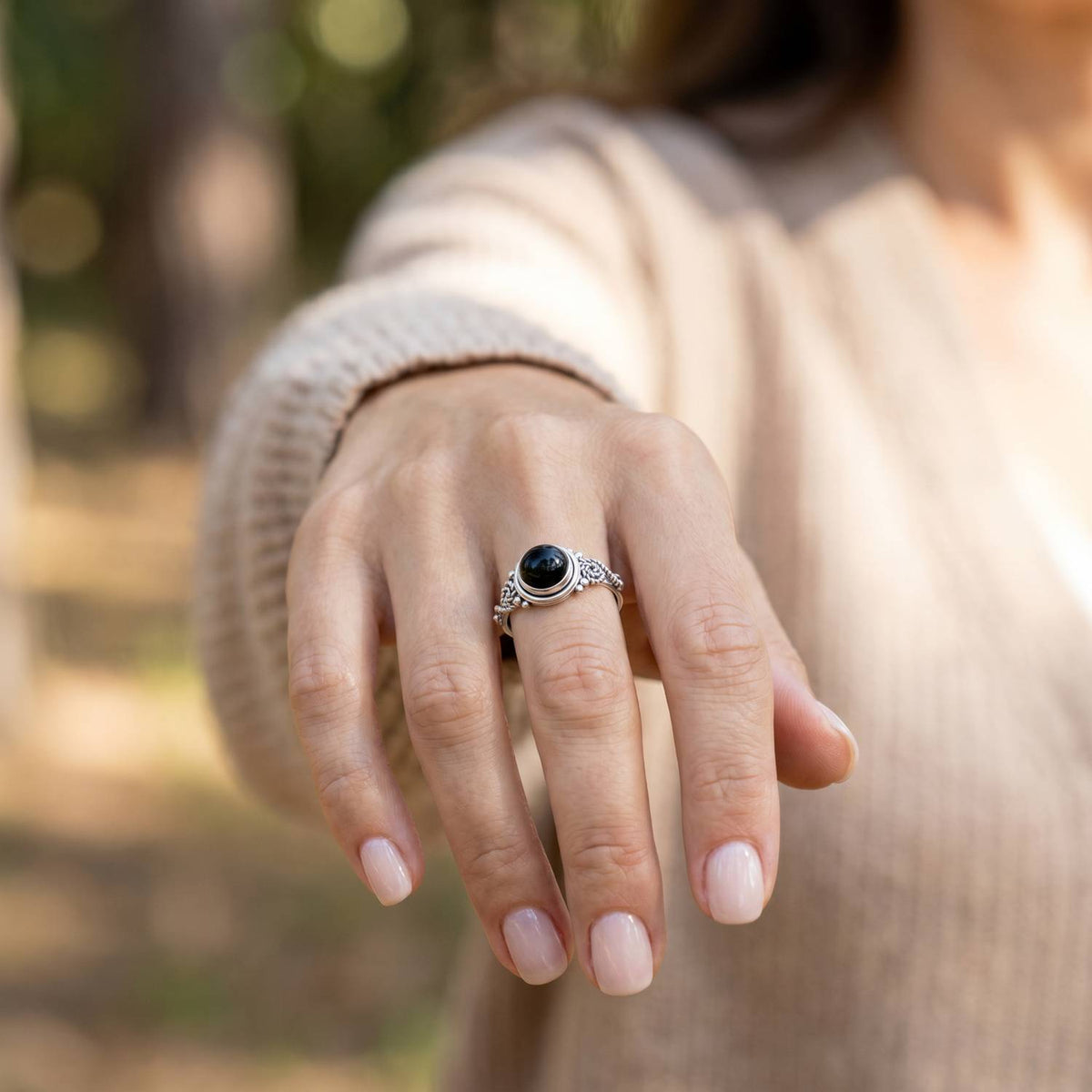 Onyxring aus Silber getragen an der Hand im Freien