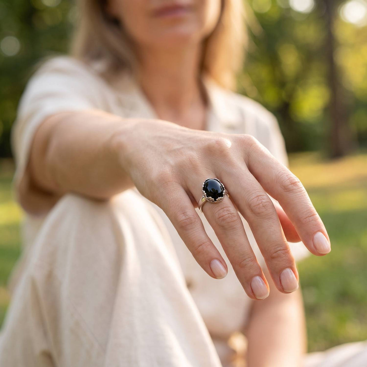 Onyxring aus Silber getragen an der Hand im Freien