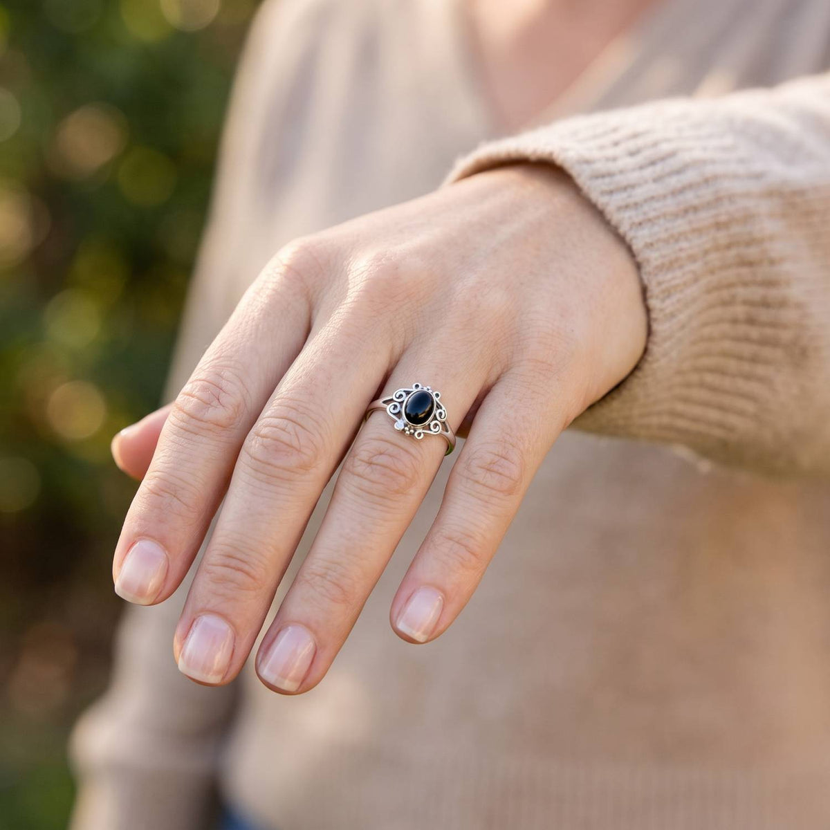 Onyxring aus Silber getragen an der Hand im Freien