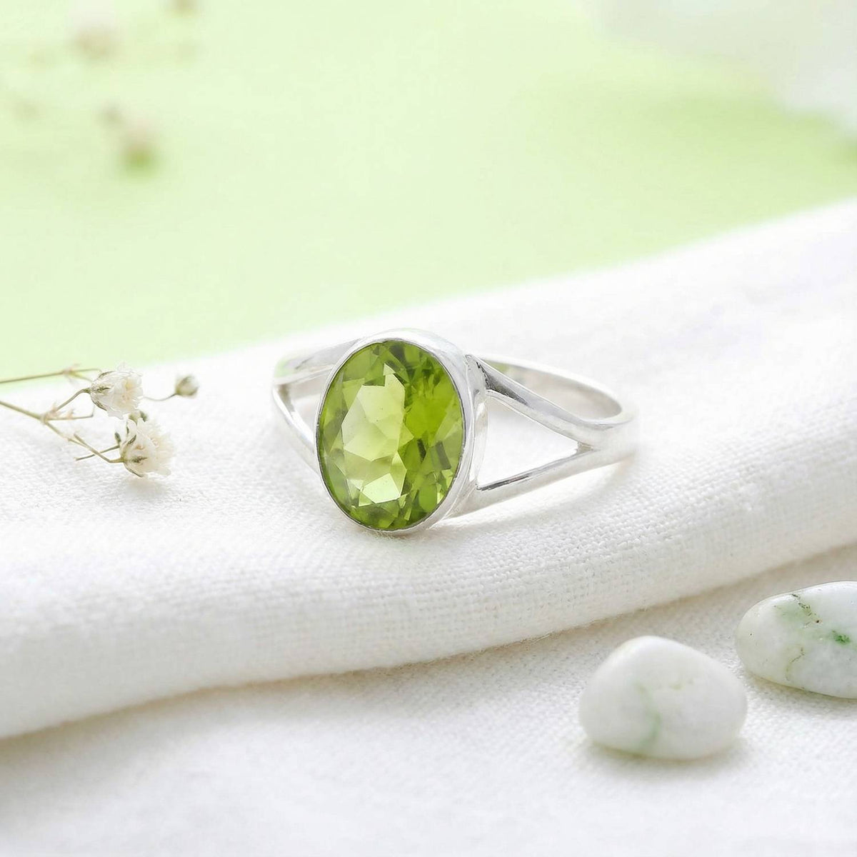 Silberring mit Peridot auf hellem Stoff