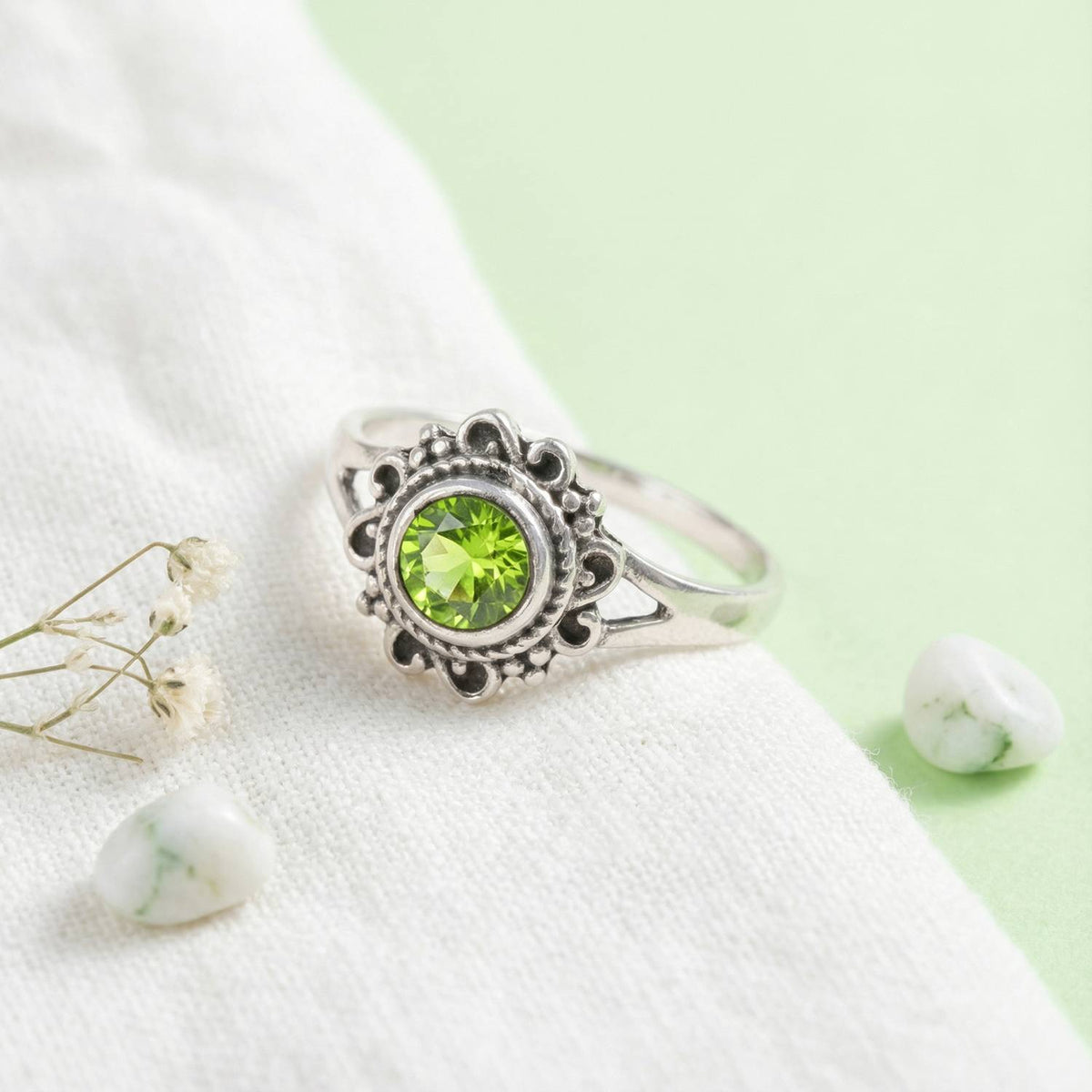 Silberring mit Peridot auf hellem Stoff