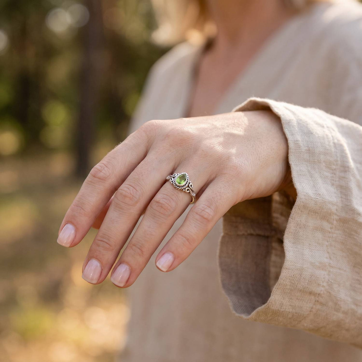 Peridotring aus Silber getragen an der Hand im Freien