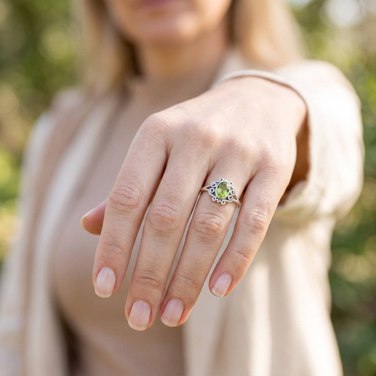 Peridotring aus Silber getragen an der Hand im Freien
