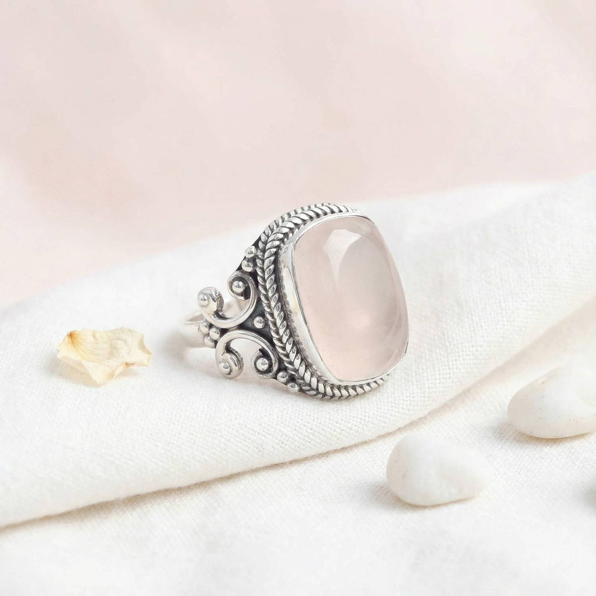 Silberring mit Rosenquarz auf hellem Stoff