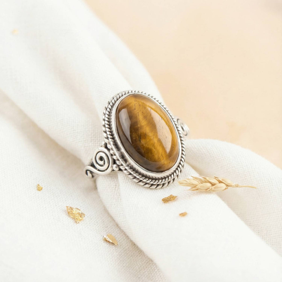 Silberring mit Tigerauge auf hellem Stoff