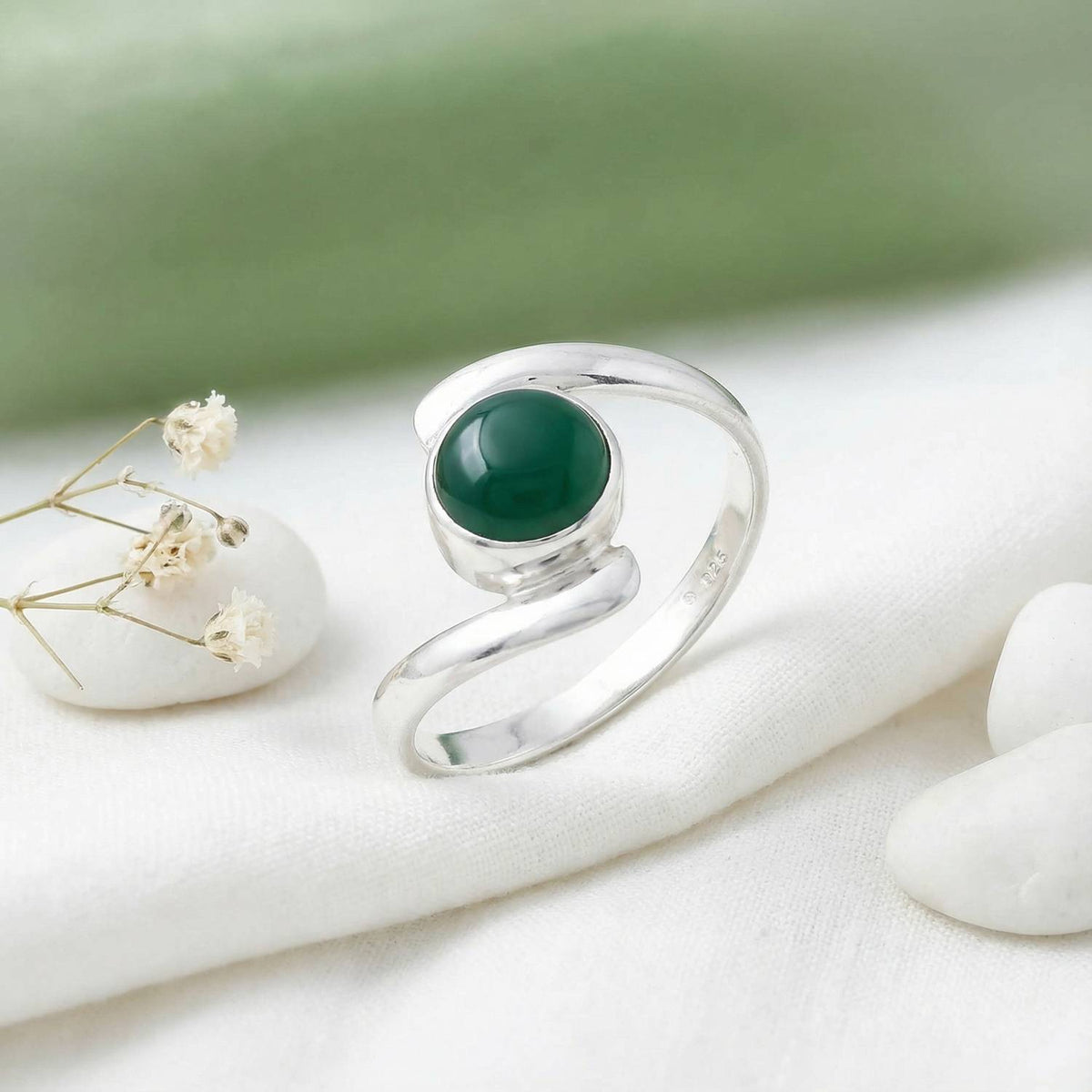 Silberring mit grüner Onyx auf hellem Stoff