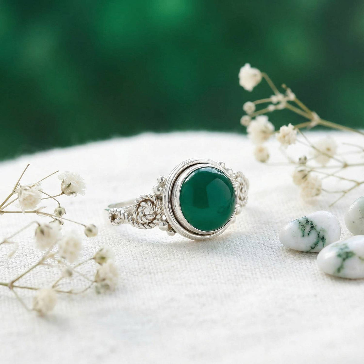 Silberring mit grüner Onyx auf hellem Stoff