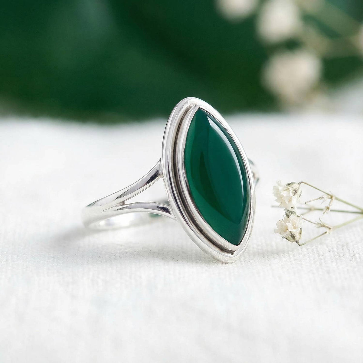 Silberring mit grüner Onyx auf hellem Stoff