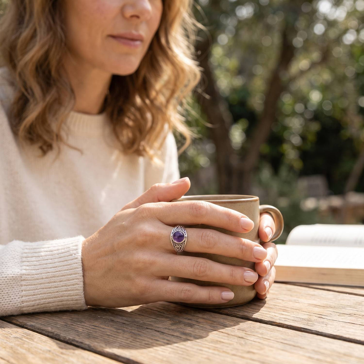 Amethystring aus Silber getragen beim Lesen mit einer Tasse
