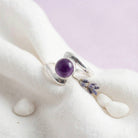 [KI] Silberring mit Amethyst auf hellem Stoff