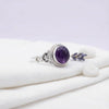 [KI] Silberring mit Amethyst auf hellem Stoff
