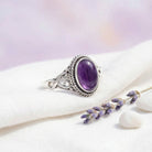 [KI] Silberring mit Amethyst auf hellem Stoff