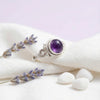 [KI] Silberring mit Amethyst auf hellem Stoff