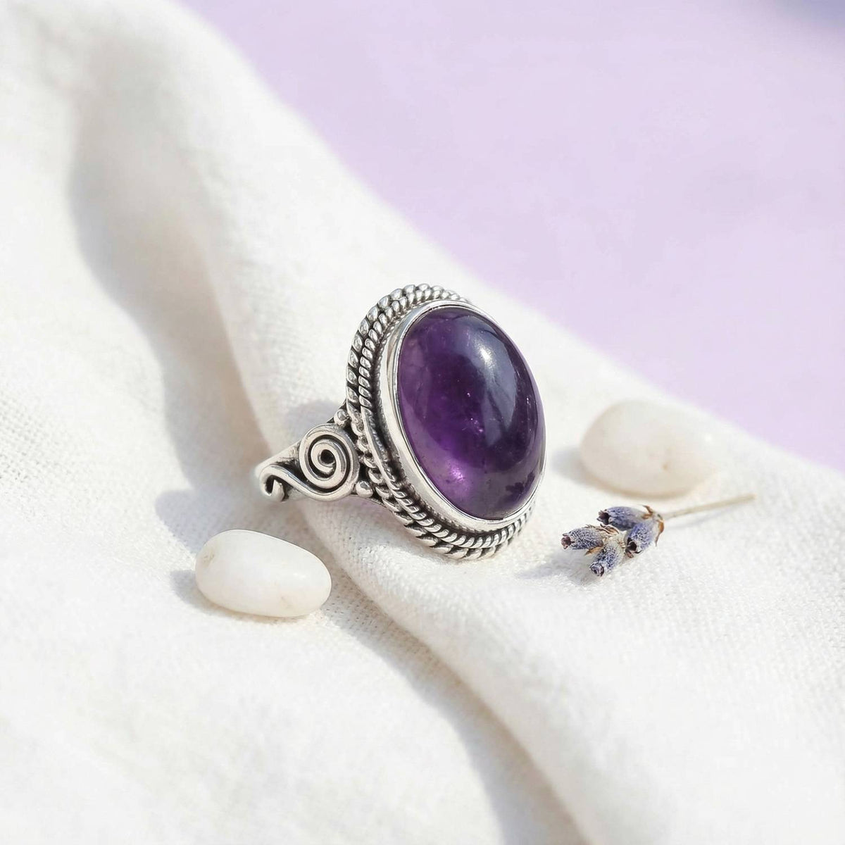 Silberring mit Amethyst auf hellem Stoff
