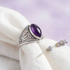 [KI] Silberring mit Amethyst auf hellem Stoff