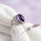 [KI] Silberring mit Amethyst auf hellem Stoff