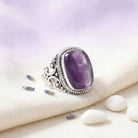 [KI] Silberring mit Amethyst auf hellem Stoff