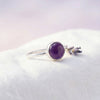 [KI] Silberring mit Amethyst auf hellem Stoff