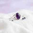 [KI] Silberring mit Amethyst auf hellem Stoff
