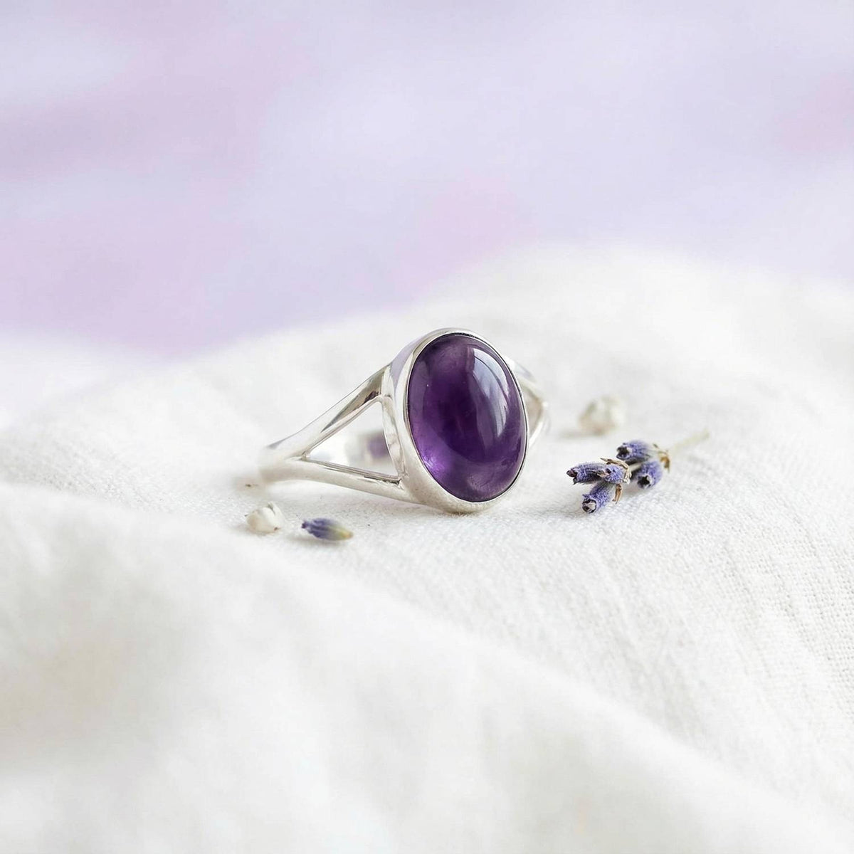 Silberring mit Amethyst auf hellem Stoff
