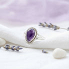 [KI] Silberring mit Amethyst auf hellem Stoff