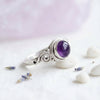 [KI] Silberring mit Amethyst auf hellem Stoff