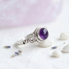 [KI] Silberring mit Amethyst auf hellem Stoff
