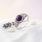 [KI] Silberring mit Amethyst auf hellem Stoff