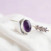 [KI] Silberring mit Amethyst auf hellem Stoff