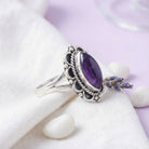 [KI] Silberring mit Amethyst auf hellem Stoff