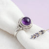 [KI] Silberring mit Amethyst auf hellem Stoff