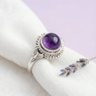 [KI] Silberring mit Amethyst auf hellem Stoff